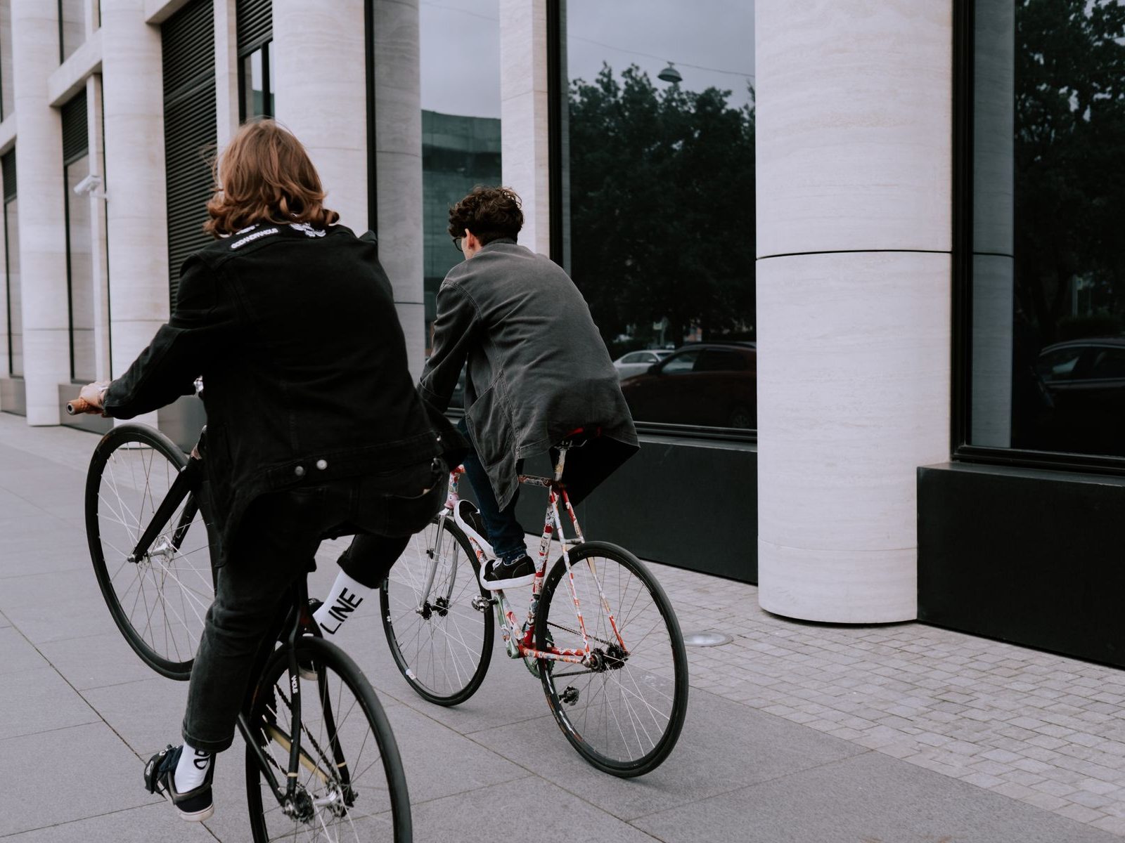 Two people riding bikes through a city